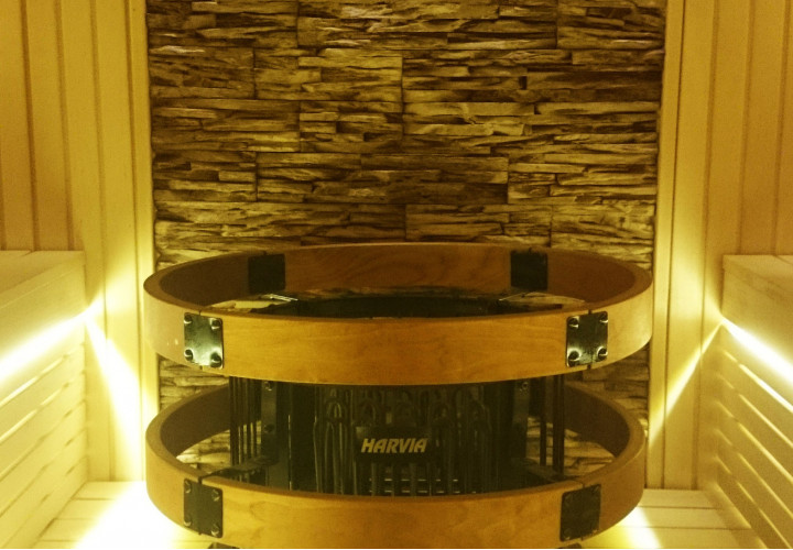 Sauna con fachada de cristal y pared de piedra