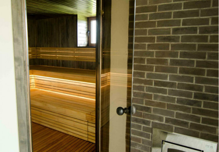 Sauna con interior y ventana de tonos oscuros.