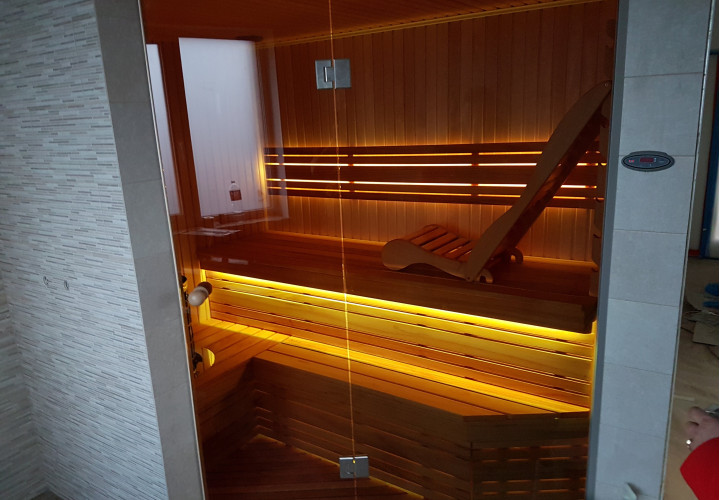 Sauna con banco ergonómico y madera de abachi