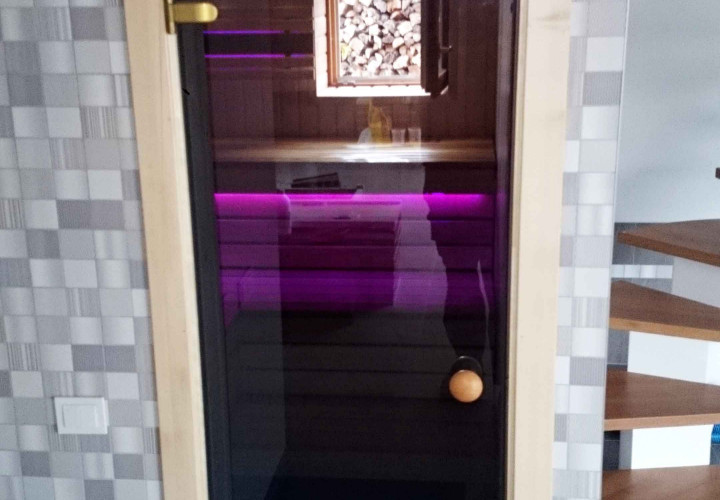 Sauna con interior de colores contrastantes y calentador que acumula calor