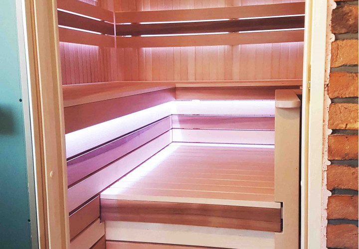 Sauna con estufa de leña y hogar externo