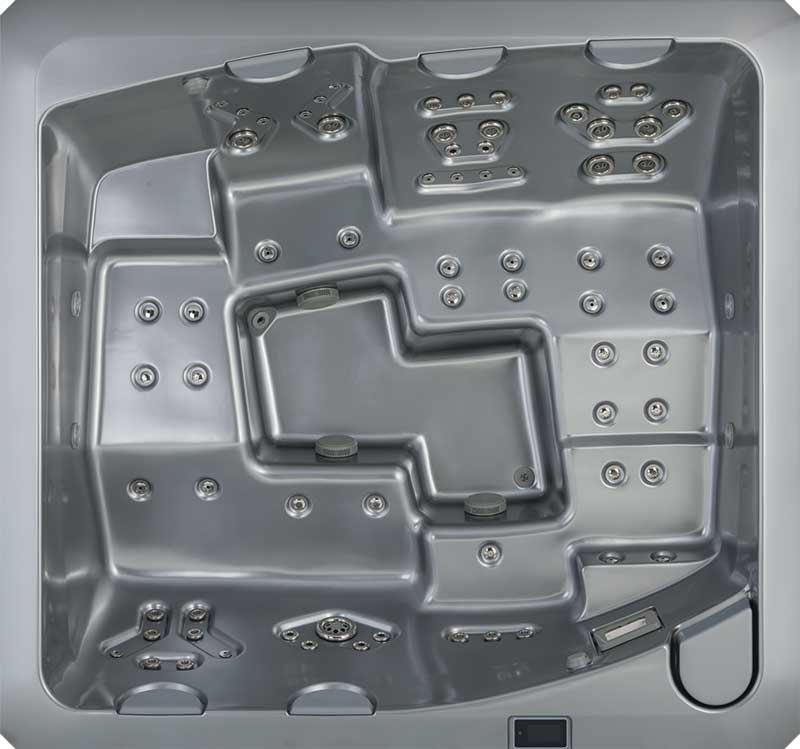 Vista superior de una piscina de hidromasaje USSPA gris con asientos ergonómicos y múltiples zonas de chorros.