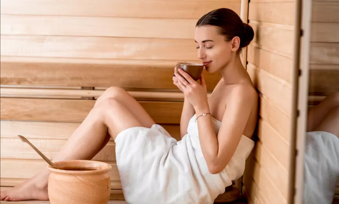 Una mujer bebe té en una sauna.
