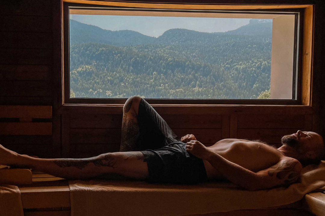 Un hombre descansa mientras está acostado en una sauna.
