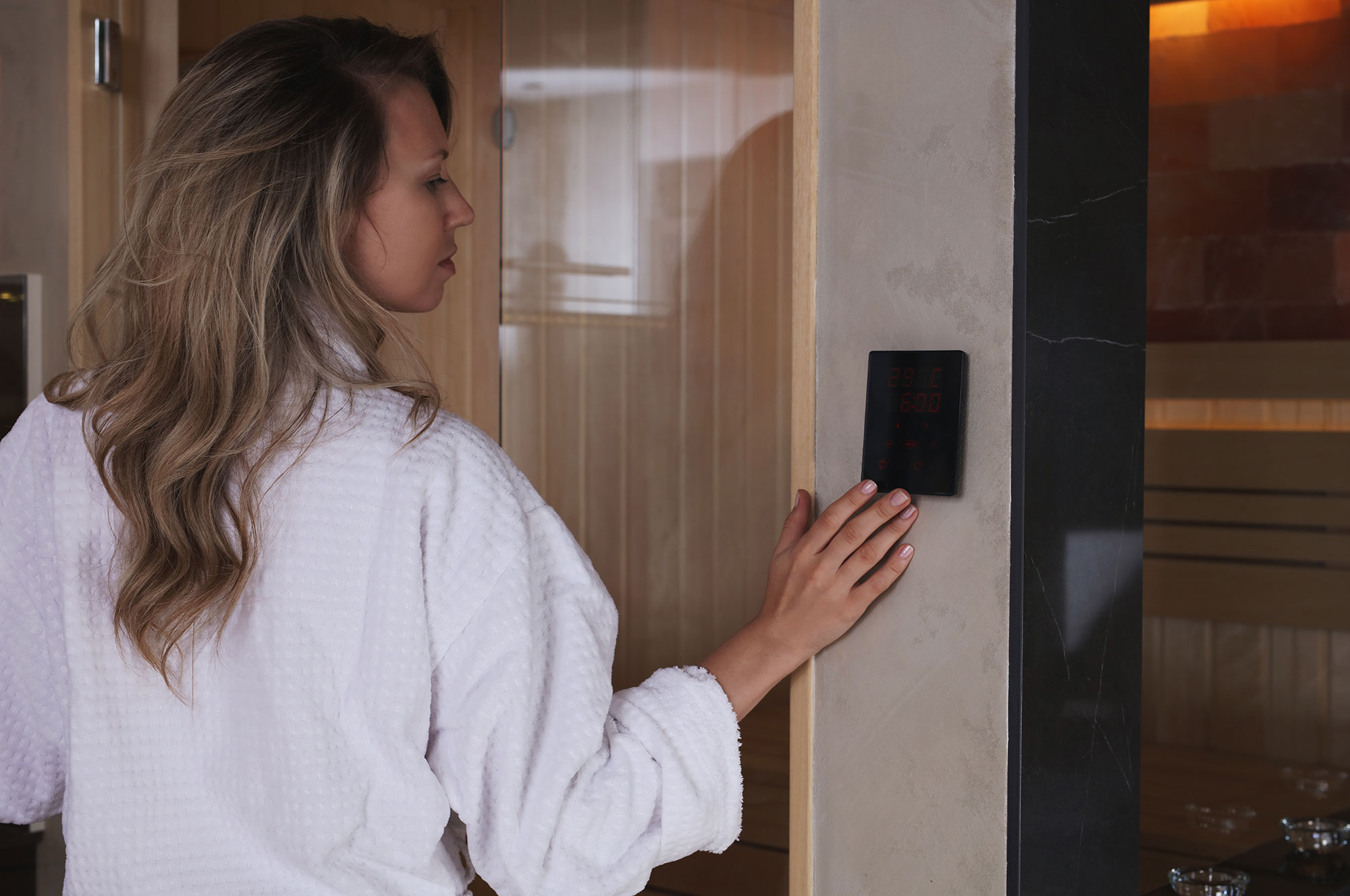 Una mujer ajusta el panel de control de la sauna.