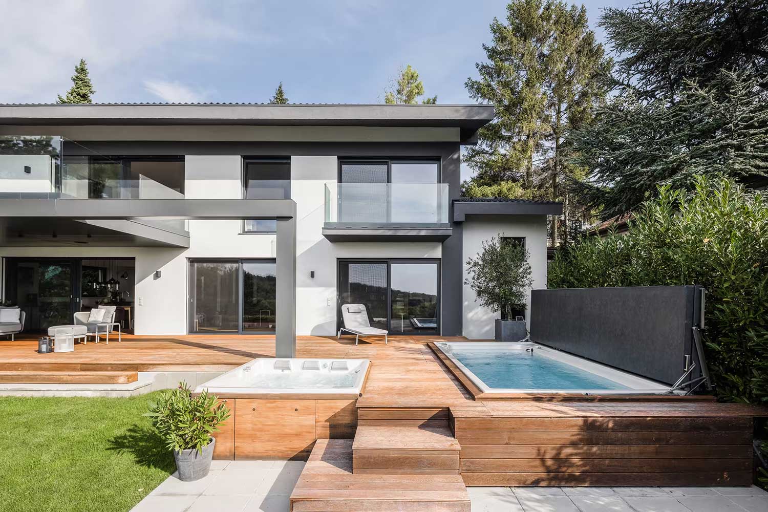 Piscinas de hidromasaje y natación USSPA con cubiertas elevadas instaladas junto a la terraza de una casa moderna.