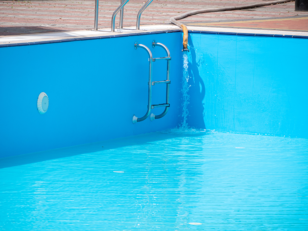 Se está llenando de agua una piscina al aire libre.