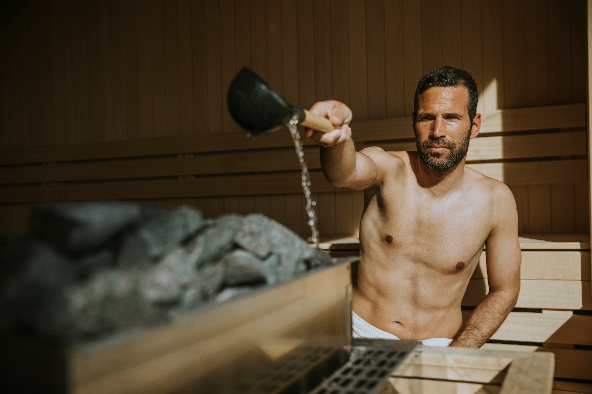 Verter agua sobre las piedras de la sauna