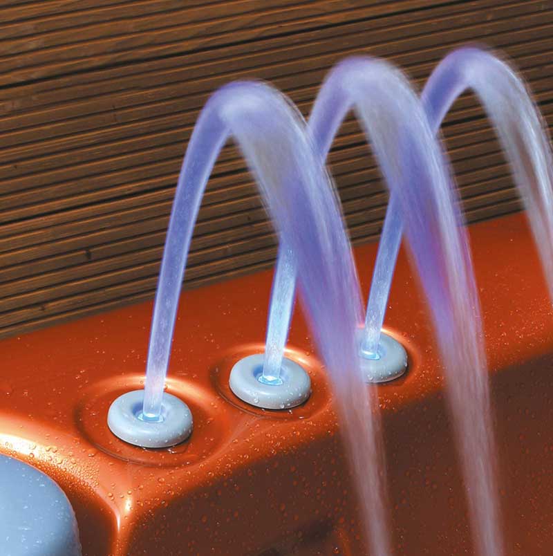 Tres chorros de agua iluminados en una piscina de spa USSPA