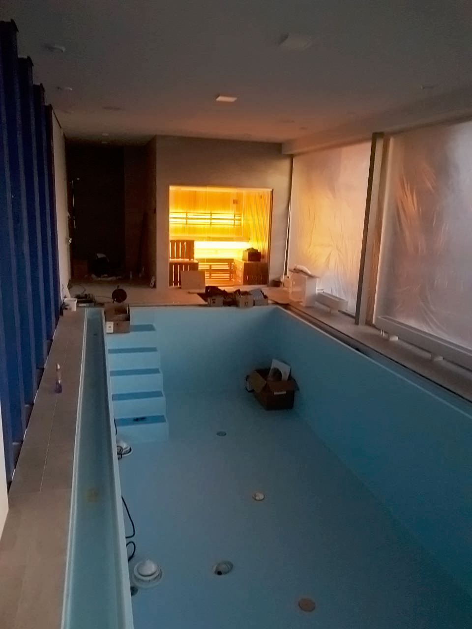 Sauna con fachada de cristal y vistas a la piscina.