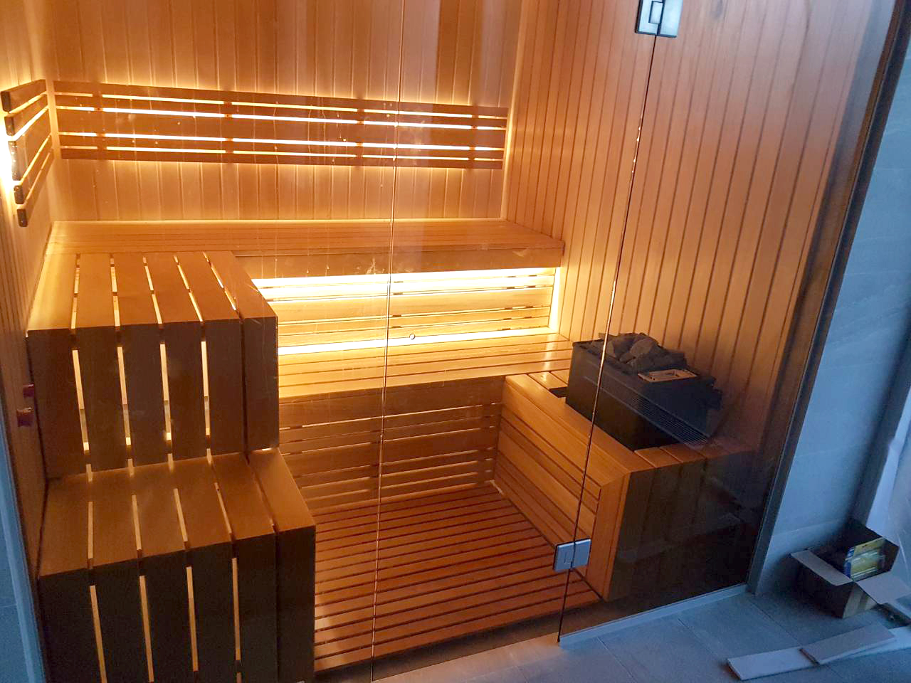 Sauna con fachada de cristal y vistas a la piscina.